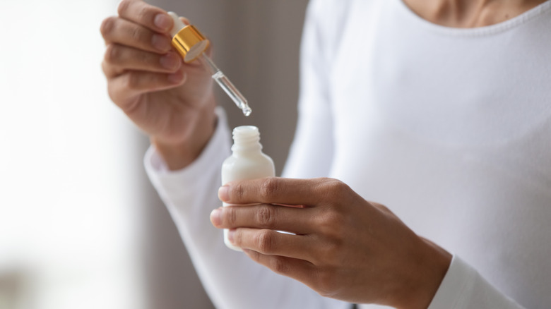 woman holding serum bottle