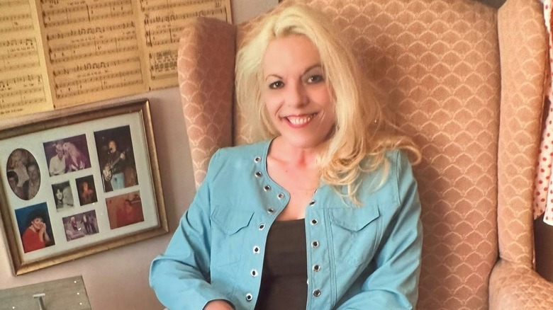 Freida Parton wearing a blue jacket and sitting on a wide chair