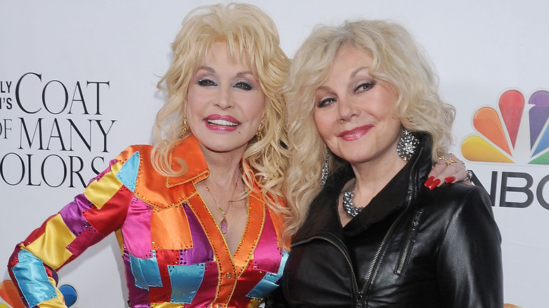 Dolly Parton and Stella Parton smiling together on a red carpet