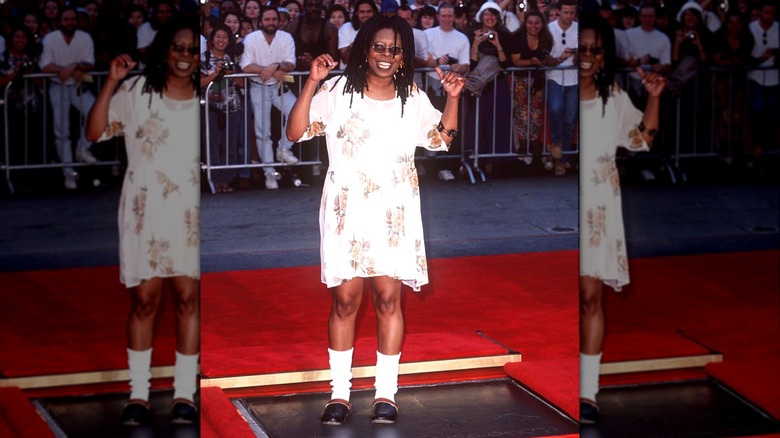 Whoopi Goldberg wearing a floral dress while leaving footprints in cement at Mann's Chinese Theater.