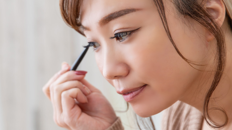 woman lining her eyelids