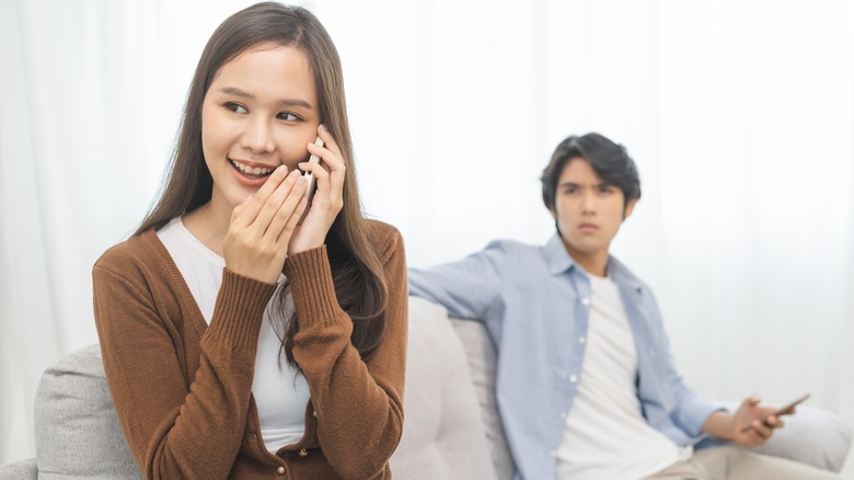 man watching woman on phone