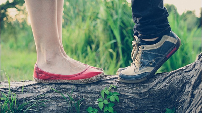 Man tiptoeing next to woman