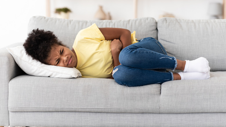 Girl in skinny jeans holding stomach