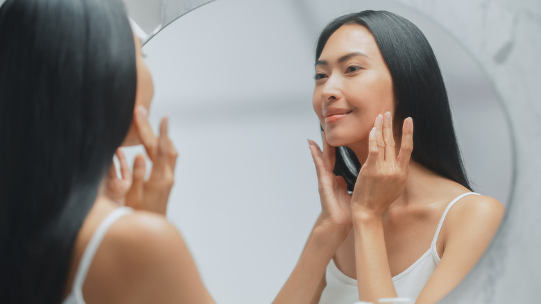 woman using lotion on face
