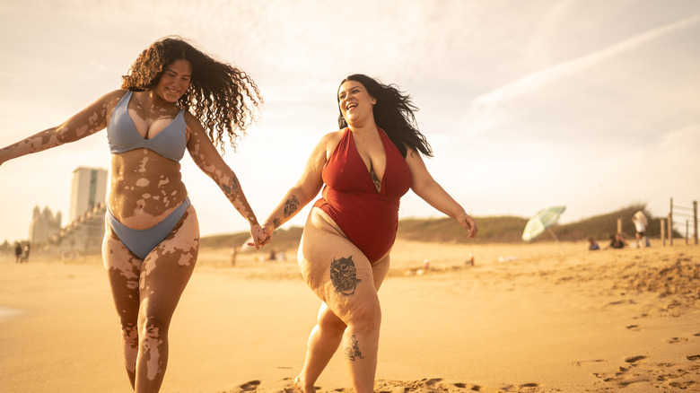Happy girls holding hands on beach