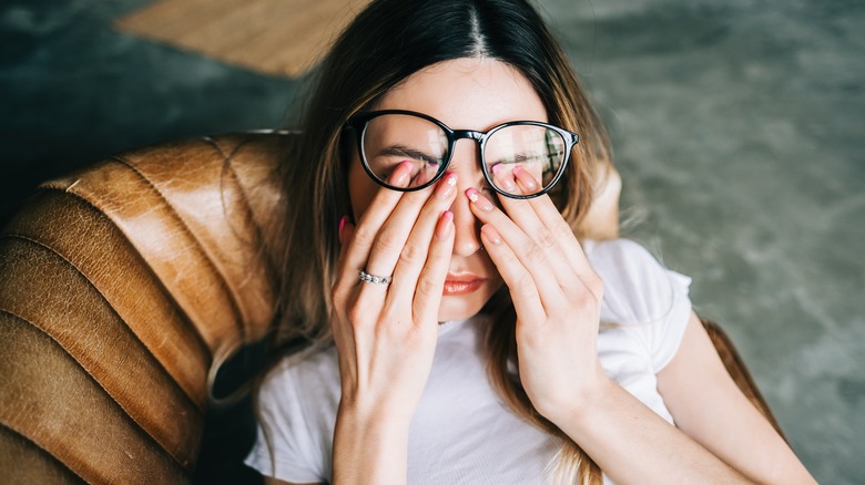 woman rubbing her eyes