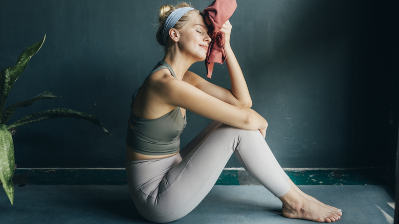 Woman sitting, sweating on mat
