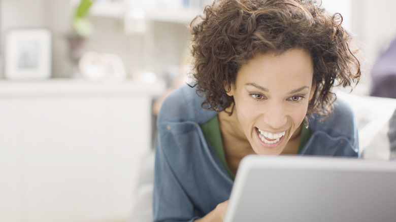 Woman laughs on computer