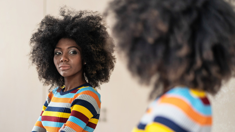 confident woman looking in mirror
