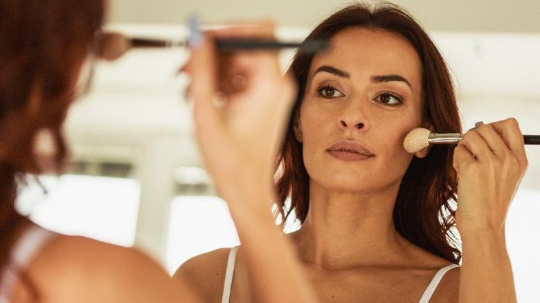 Middle aged woman applying makeup