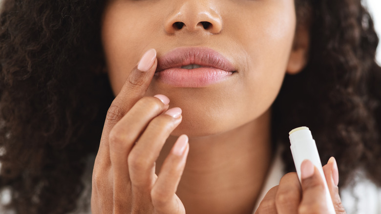 Woman applying lip balm