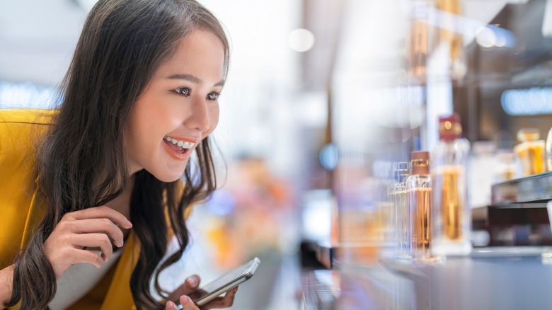 woman looking at perfume