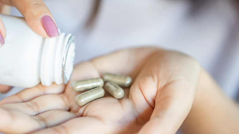 woman holding herbal supplements