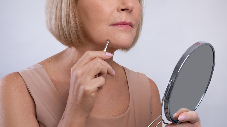 Woman plucks chin hairs