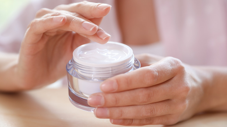 woman holding moisturizing cream