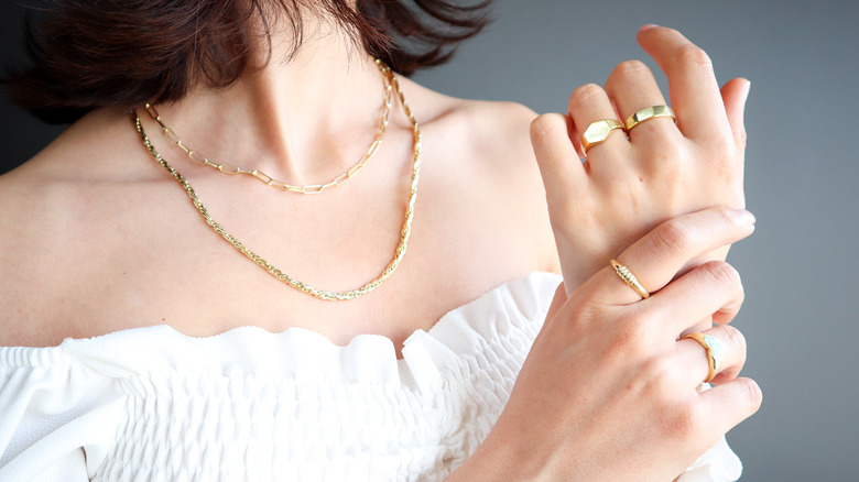 woman wearing gold necklaces and rings 