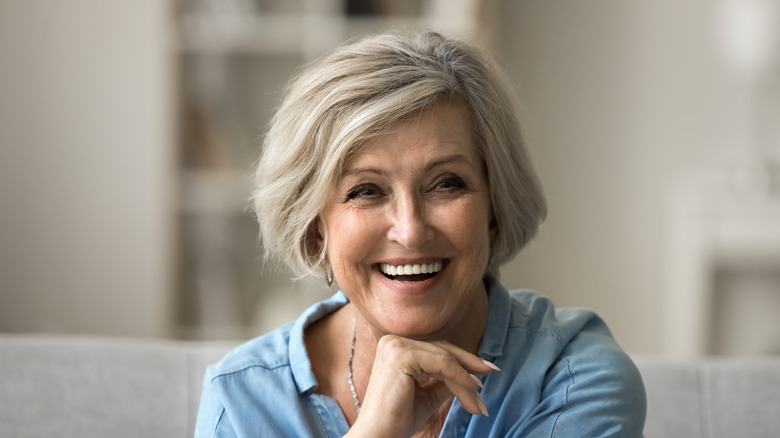 An older woman with a textured bob smiling at the camera