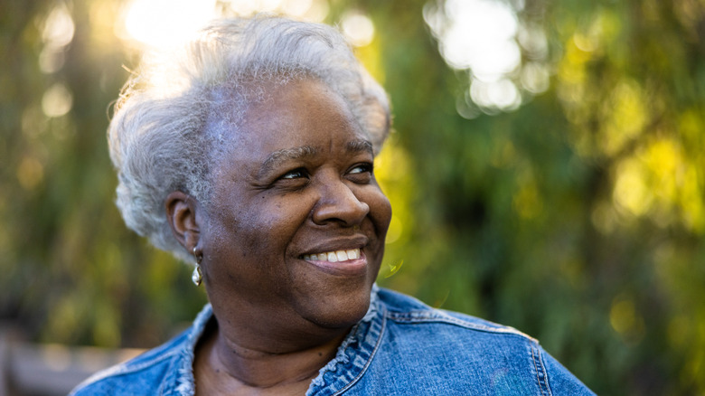 An older woman with a volumnized pixie smiling