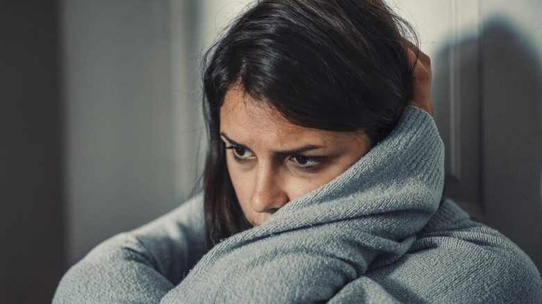 An unhappy woman hugging herself.