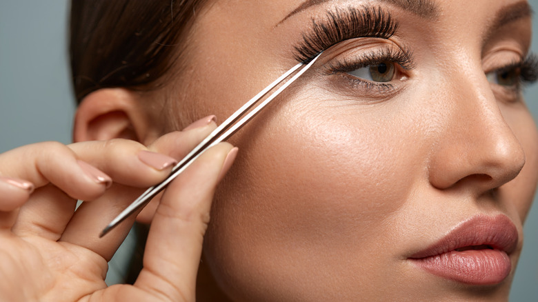 woman applying falsies