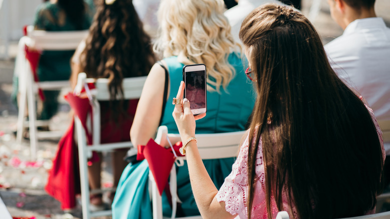 woman take picture with phone wedding