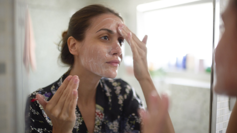 woman washing face in bathroom