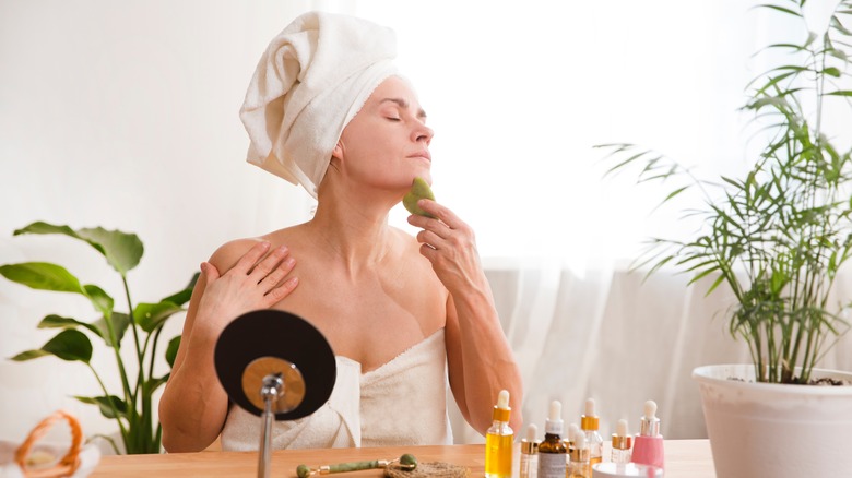 woman using gua sha on chin