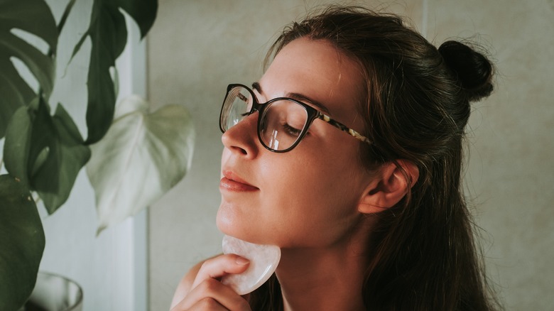 Woman using gua sha on chin