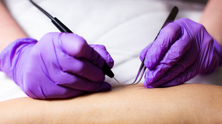 technician holding tweezer and probe