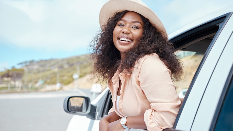 Woman hanging out of car
