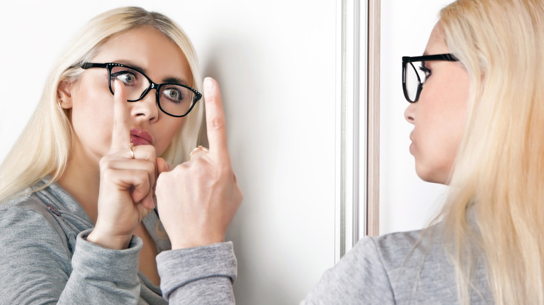 woman shaking finger at her reflection