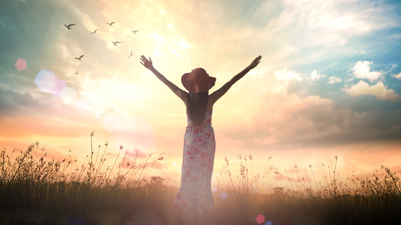 Woman surrendering in field