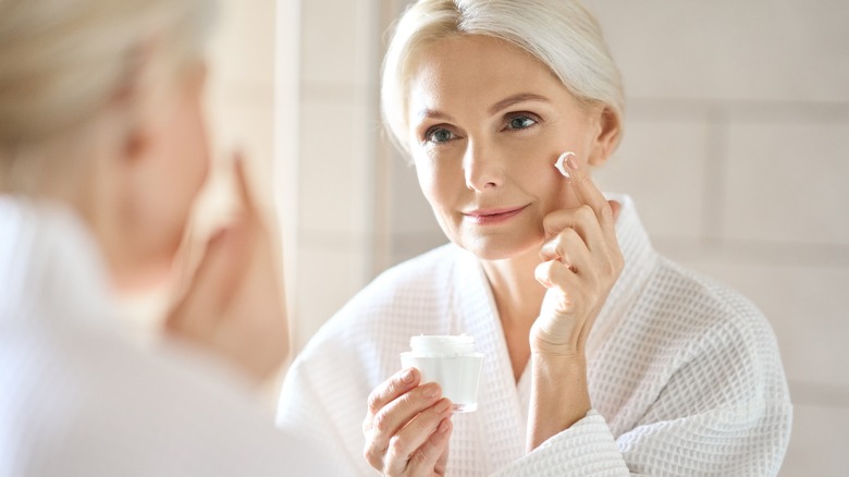 older woman applying skincare