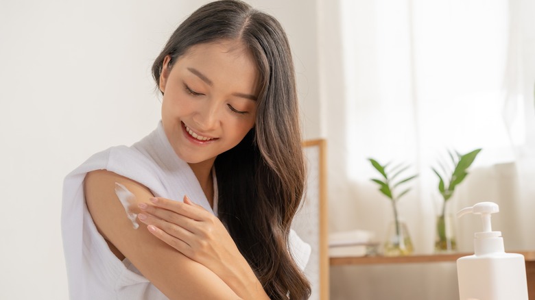 Woman applying body cream