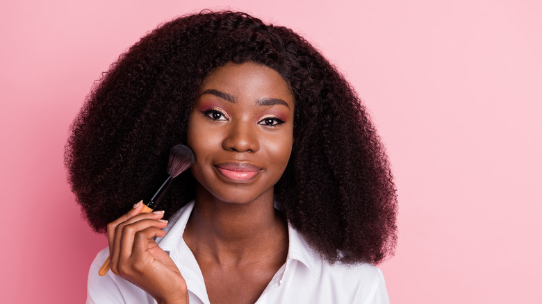 young woman applying blush