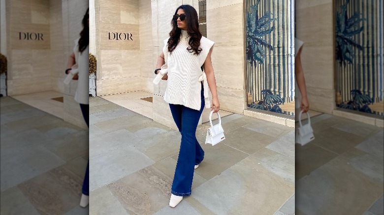 Woman wearing heeled booties with flared jeans.