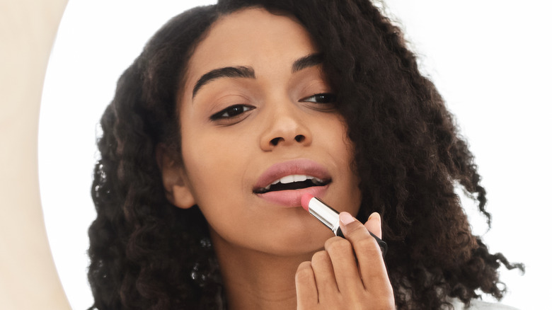 person putting on lipstick