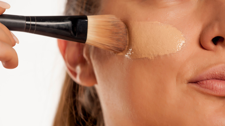 person putting on foundation