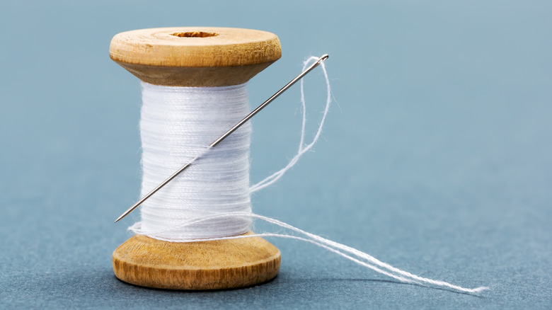 White thread and needle on spool