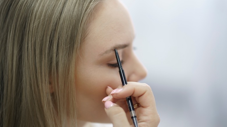 Woman measuring eyebrows