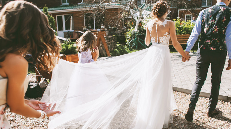 Bridesmaid holding wedding dress train