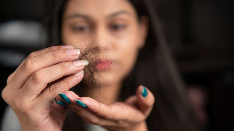 woman holding clump of hair