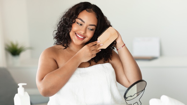 woman brushing her damp curly hair