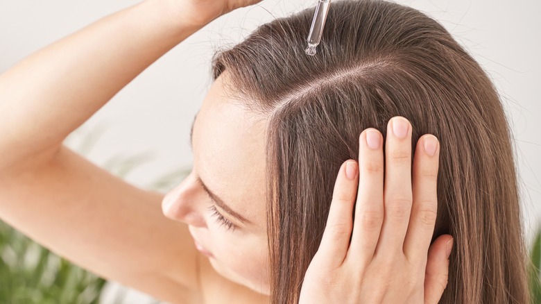 woman apply hair serum