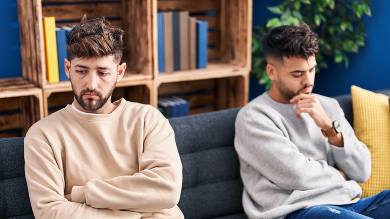 Unhappy gay couple on sofa