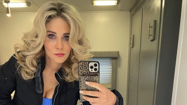 Zooey Deschanel with curly blond hair behind the scenes of "Physical"