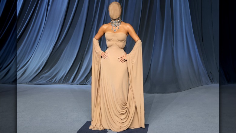 Kim Kardashian wearing a tan dress with a tan face coverup