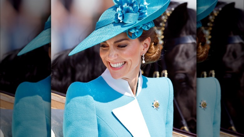 Kate Middleton in a carriage for 2025 Trooping the Colour. She is wearing a blue and white coat dress